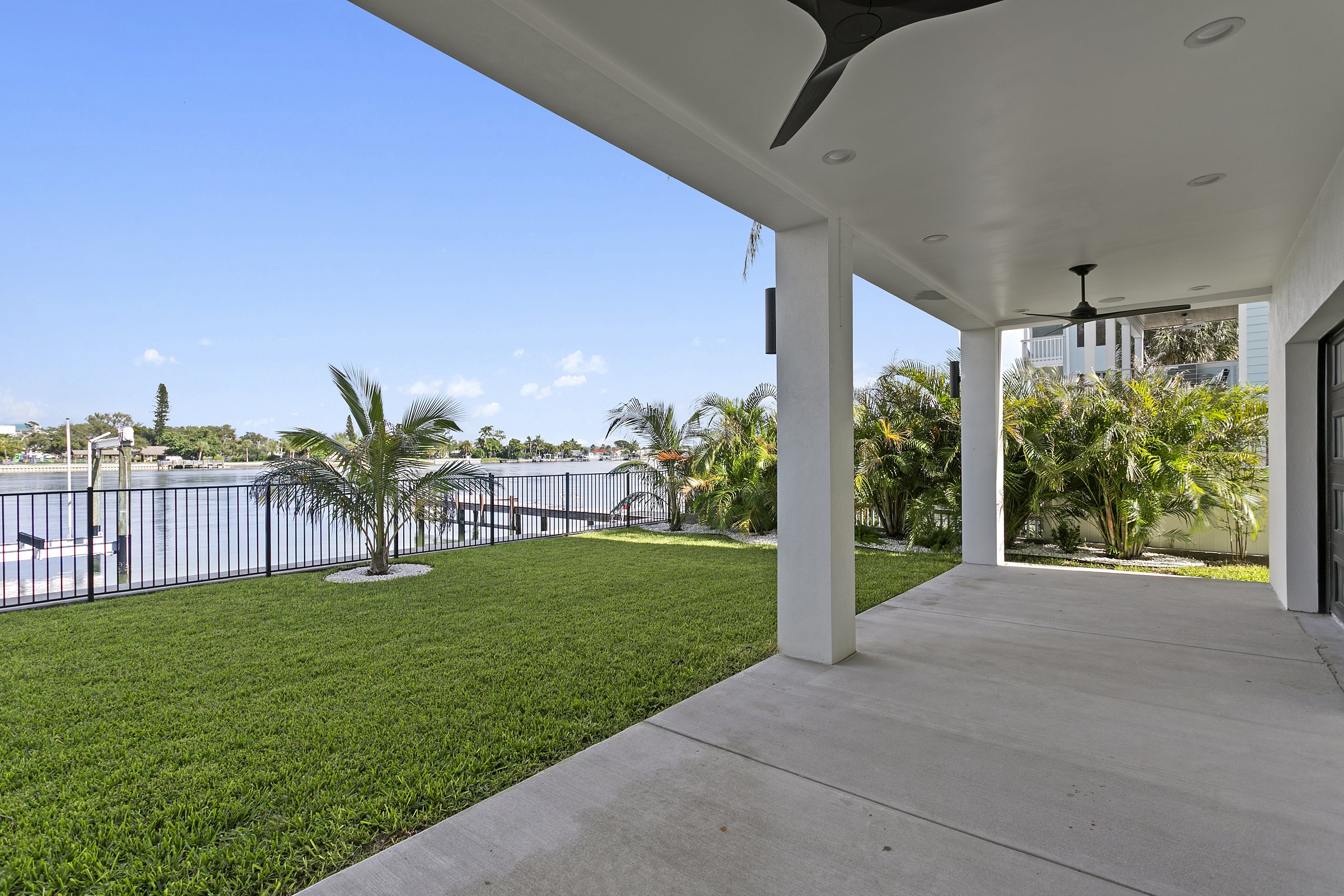Waterfront yard with palms and lawn